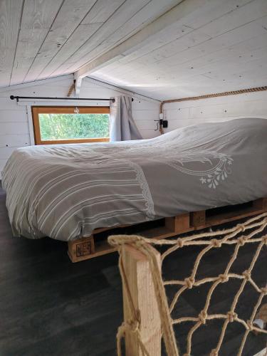 a bed in a tiny house with a window at La tiny house in Bissières
