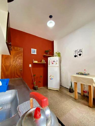 a kitchen with a table and a white refrigerator at Shekináh in Villa Cura Brochero