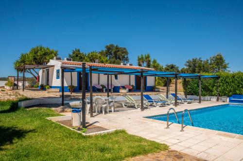 a villa with a swimming pool and a house at Monte Pedras Negras in São Luis