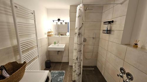 a white bathroom with a sink and a shower at Studio- Gemütlich, Charmant, Zentral in Landsberg am Lech