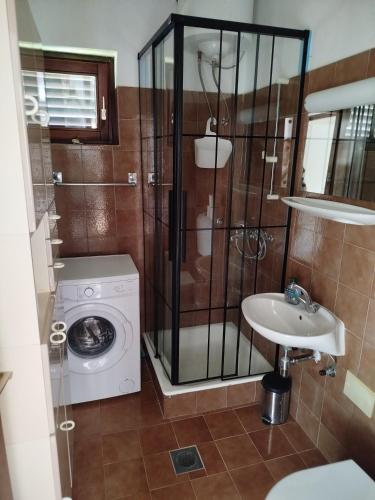 a bathroom with a washing machine and a sink at Apartment Hribar in Labin
