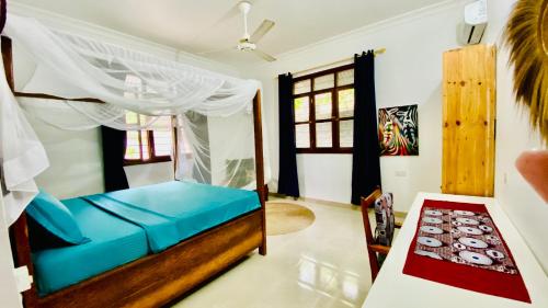 a bedroom with a bed and a table in a room at Fish House in Nungwi