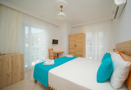 a bedroom with a large bed with blue pillows at Kampüs Garden in Fethiye