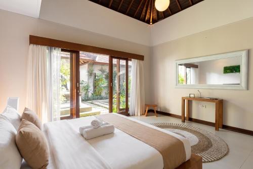 a bedroom with a large bed with a mirror at Villa Lapiz Lazuli - Seminyak Kuta Luxury Private Pool Villas in Seminyak
