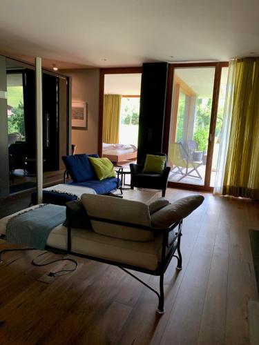 a living room with a couch and a living room withwindows at Chalet Park Apartment mit Sauna Hamam in Diemtigen
