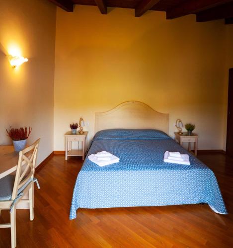 a bedroom with a blue bed with two towels on it at Agriturismo Hermada in Duino