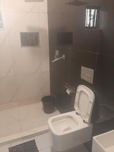 a bathroom with a white toilet and a sink at Jasper luxury homes in Abuja