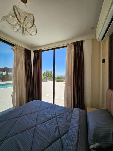 a bedroom with a bed and a large window at Sun farm souf in Jerash