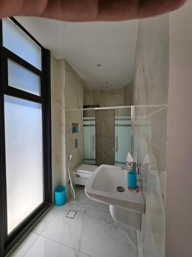 a bathroom with a tub and a sink and a window at Sun farm souf in Jerash