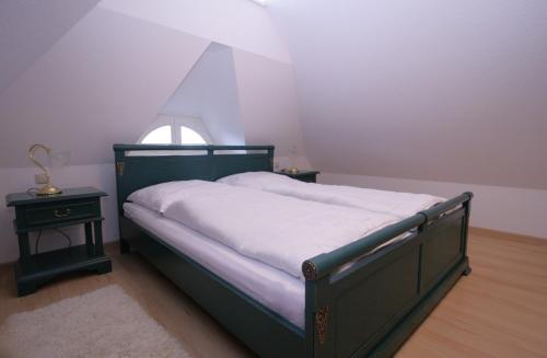 a bedroom with a bed and a small window at Haus Koppelweg FW-Fisch in Ahrenshoop