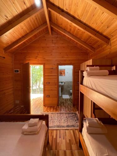 a room with two beds in a wooden house at Shija e Natyres in Reç