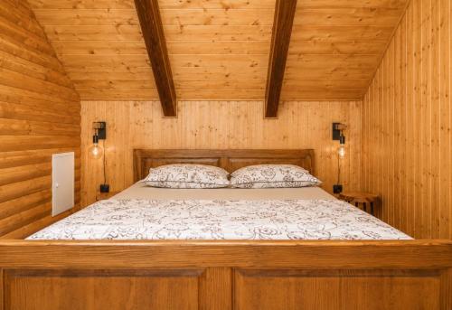 a bedroom with a bed in a wooden cabin at Kuća za odmor Cozy Bear Cabin in Brestova Draga