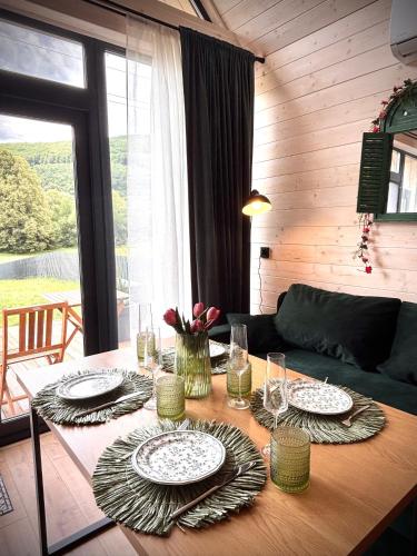 a table with plates and glasses on top of it at Carpathian Barns in Abranka