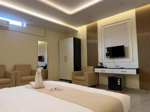 a hotel room with a large bed and a television at Hotel Shanvi Inn in Jabalpur