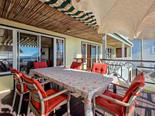 a dining table and chairs on a balcony at Eindelik in Simonʼs Town