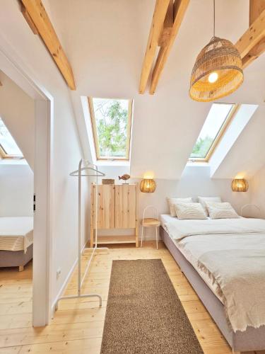 a bedroom with white walls and a bed and a rug at Morze Las in Ustka