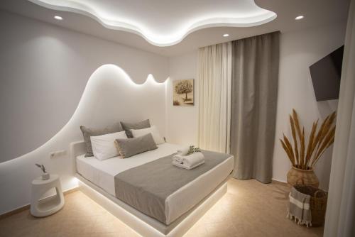 a white bedroom with a bed with a white ceiling at Aurora Horizon Naxos in Glinádhon