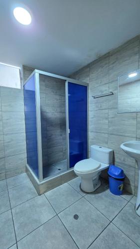 a bathroom with a toilet and a shower and a sink at Hotel Lirios Dorados in Iquitos