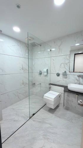 a bathroom with a shower and a toilet and a sink at Hotel Darshan Inn in Anand
