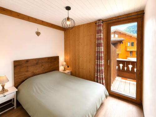 a bedroom with a bed and a window at L'edelweiss in La Plagne Tarentaise