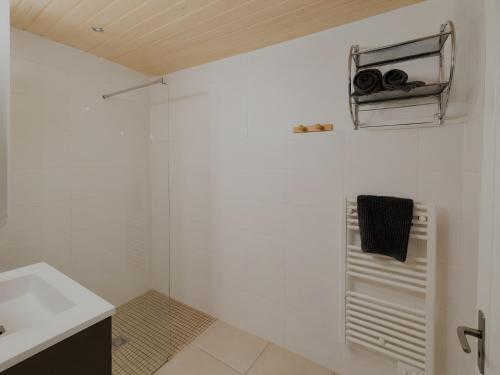 a white bathroom with a sink and a towel at L'edelweiss in La Plagne Tarentaise