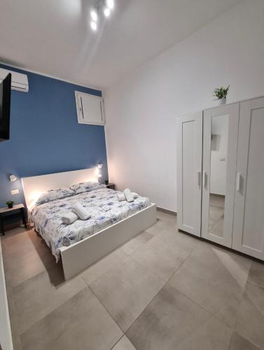 a bedroom with a bed and a blue wall at Holiday Home B&M Apt2 -Apt3 in Pozzallo