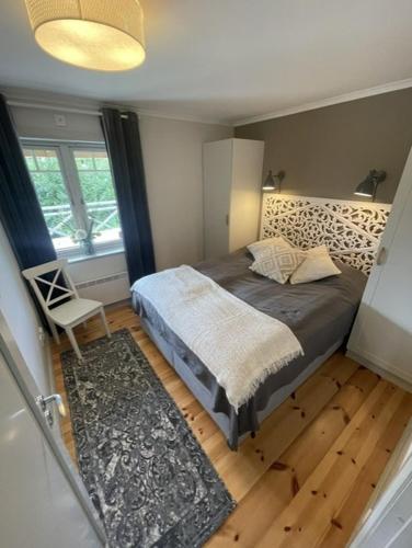 a bedroom with a bed and a chair and a window at Järvsöbranten 7 med 10 sovplatser och vedeldad badtunna, 400 m från lift in Järvsö