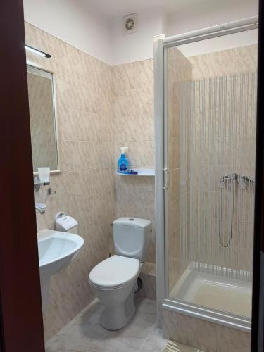 a bathroom with a toilet and a shower and a sink at Reda in Rowy