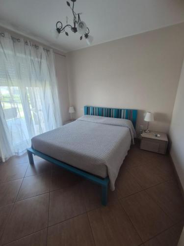 a bedroom with a bed and a large window at Le Dune per 4 - Appartamento con vista mare in Silvi Paese