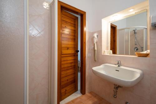 ein Badezimmer mit Waschbecken und Spiegel in der Unterkunft Hotel Valdiola in Porto Cervo