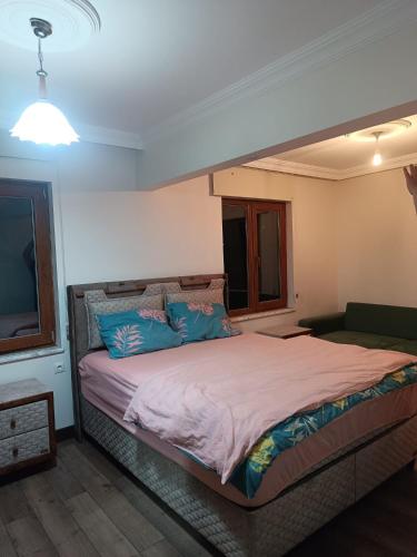 a bedroom with a large bed with blue pillows at Deniz house apart in Güzelce