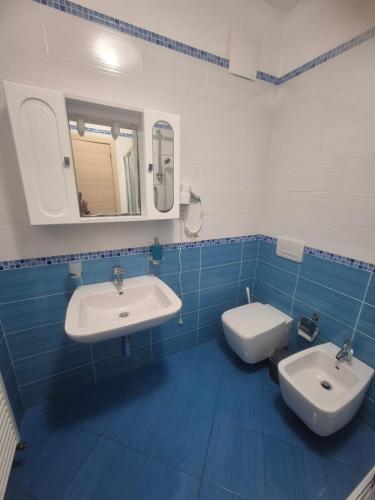 a blue and white bathroom with two sinks and a toilet at Le Dune per 4 - Appartamento con vista mare in Silvi Paese