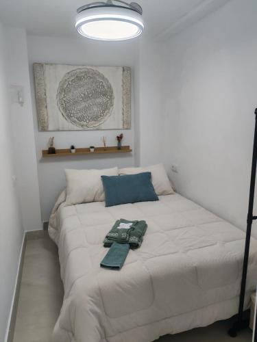 a bedroom with a white bed with two pillows at Ancha 4 en pleno centro in Sanlúcar de Barrameda