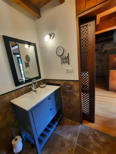 a bathroom with a blue sink and a mirror at El Portalon de Luena in Cuena