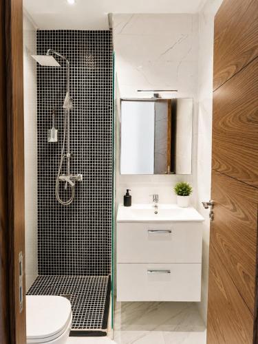 a bathroom with a white sink and a shower at Mehdia Beach Apartment in Kenitra