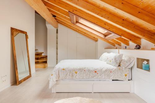 a bedroom with a white bed and wooden ceilings at Duplex in Durango's old town in Durango