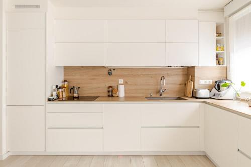 a white kitchen with white cabinets and a sink at Duplex in Durango's old town in Durango