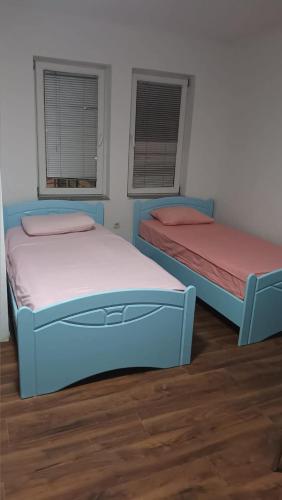 two beds in a room with two windows at Charshija in Struga