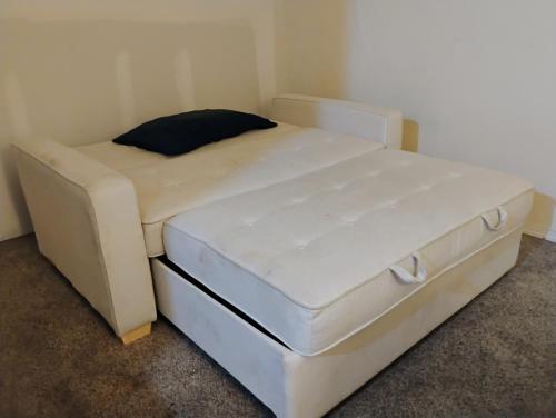 a white bed in a corner of a room at 1 bedroom in 3 BR condo in Tukwila