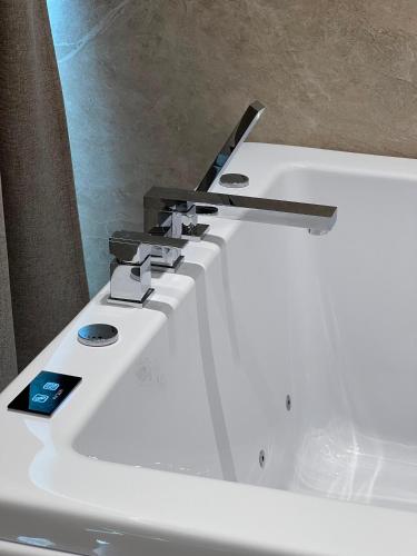 a white sink with a remote control on top of it at Blue Waves Hotel & Suites in Sarandë