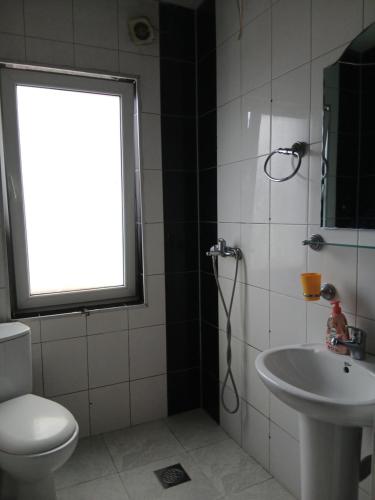 a bathroom with a toilet and a sink and a window at Charshija in Struga