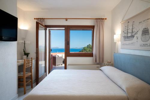 ein Schlafzimmer mit einem Bett und Meerblick in der Unterkunft Hotel Valdiola in Porto Cervo
