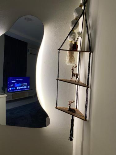 a shelf on a wall with a lamp and a mirror at شقه in Ar Rass