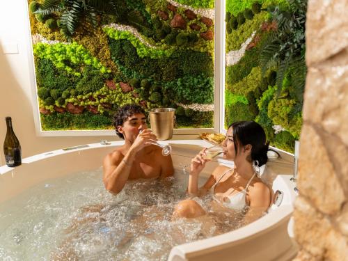 two people sitting in a bath tub eating food at SOLE e LUNA - JACUZZI e RELAX in Neviano