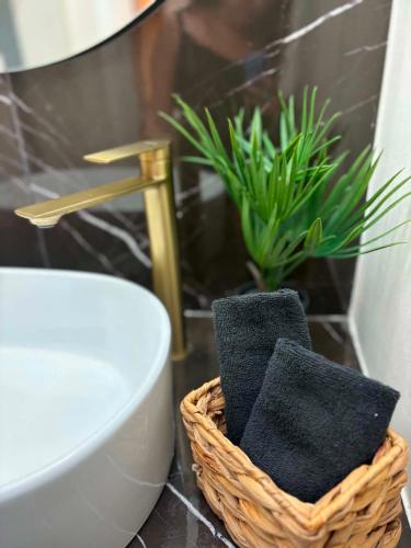 a bathroom with a basket of towels and a plant at Alegria Suite in Ermoupoli
