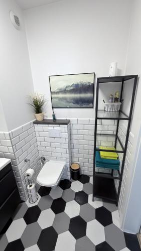a bathroom with a black and white checkered floor at Wodniak in Ostróda