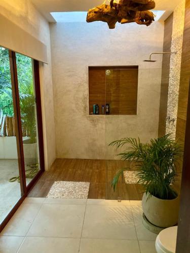 a room with a bathroom with a toilet and a plant at Niik Tulum in Tulum