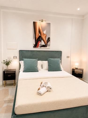 ein Schlafzimmer mit einem Bett, auf dem ein Paar Schuhe liegt in der Unterkunft Crazi Suites in Nola