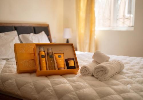 a box of cosmetics sitting on a bed with towels at Beach Walk Apartment with Private Garden & Wifi in Grand-Baie