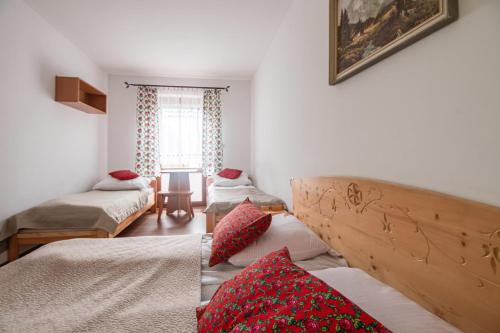 a room with three beds and a window at Willa Dunajec in Zakopane